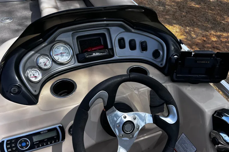 Slide: The Image of 2017 Sun Tracker Party Barge 22 DLX dashboard with steering wheel and gauges. - 9