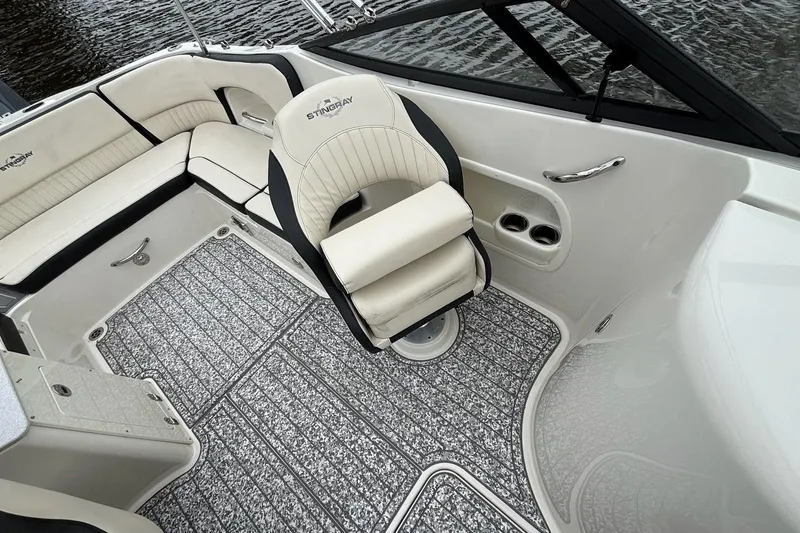 Slide: The Image of 2021 Stingray 231 DC boat interior with white seating and storage compartments. - 12