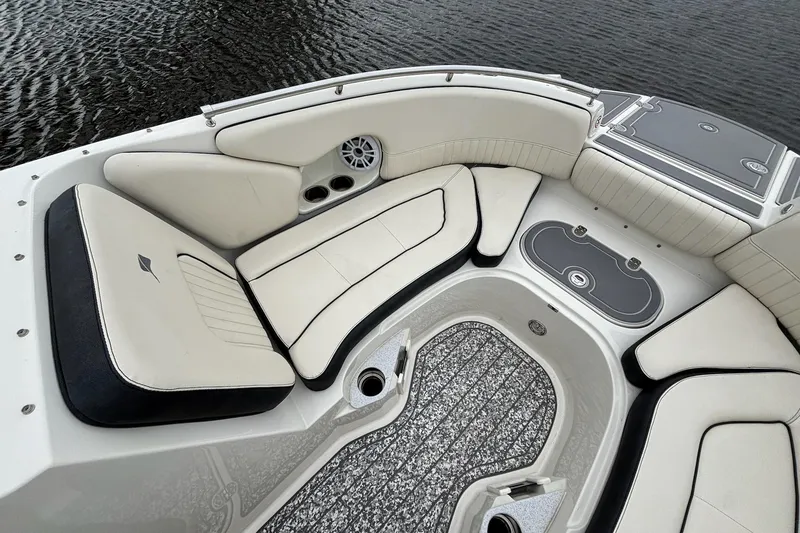 Slide: The Image of 2021 Stingray 231 DC boat interior with white cushioned seating and cup holders. - 13
