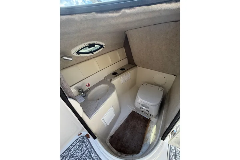 Slide: The Image of 2021 Stingray 231 DC boat interior with compact bathroom, featuring sink and toilet. - 26