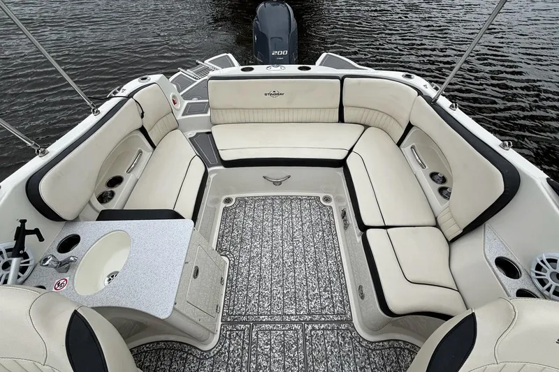 Slide: The Image of 2021 Stingray 231 DC boat interior with spacious seating and sleek design on the water. - 7