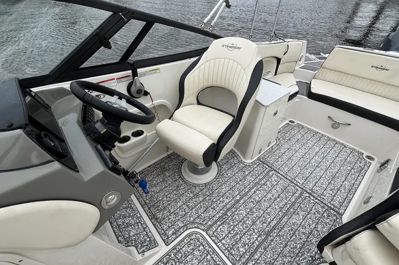 Slide: The Image of 2021 Stingray 231 DC boat interior with steering wheel, captain's chair, and seating. - 8