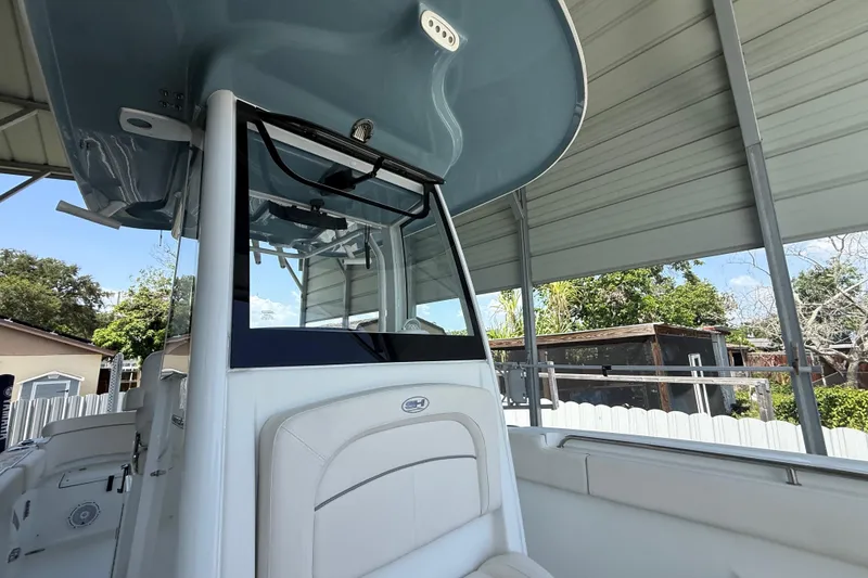 Slide: The Image of 2023 Sea Hunt Ultra 239 SE boat under a metal canopy, showcasing sleek design and modern features. - 20