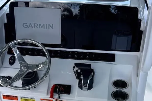 Slide: The Image of 2023 Sea Hunt Ultra 239 SE boat dashboard with Garmin navigation system and steering wheel. - 12