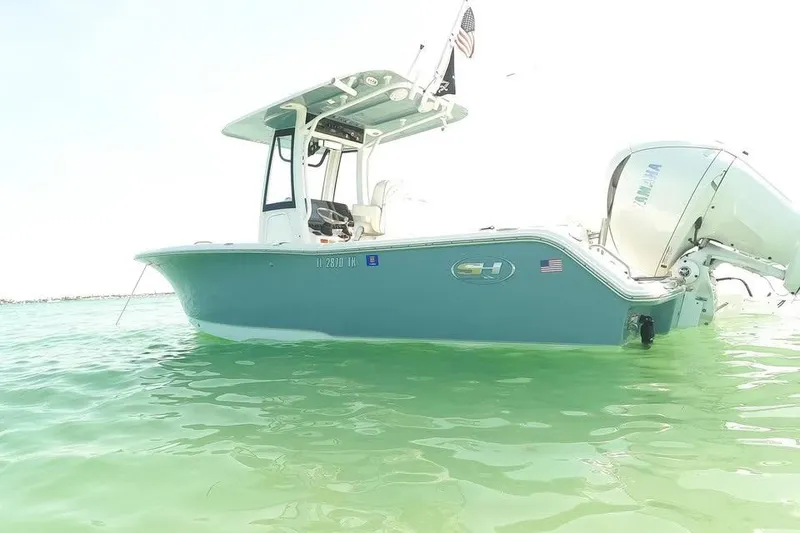 Slide: The Image of 2023 Sea Hunt Ultra 239 SE boat floating on clear turquoise water. - 17