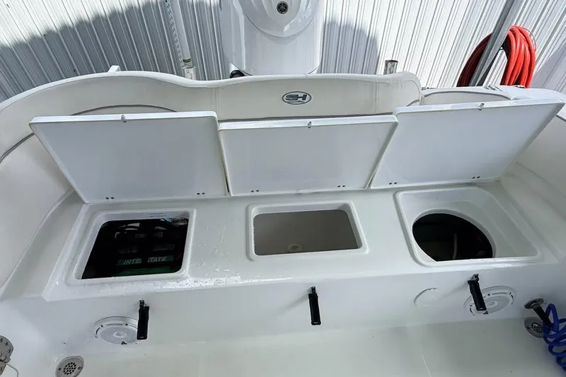 Slide: The Image of 2023 Sea Hunt Ultra 239 SE boat storage compartments with open lids, showcasing interior features. - 2