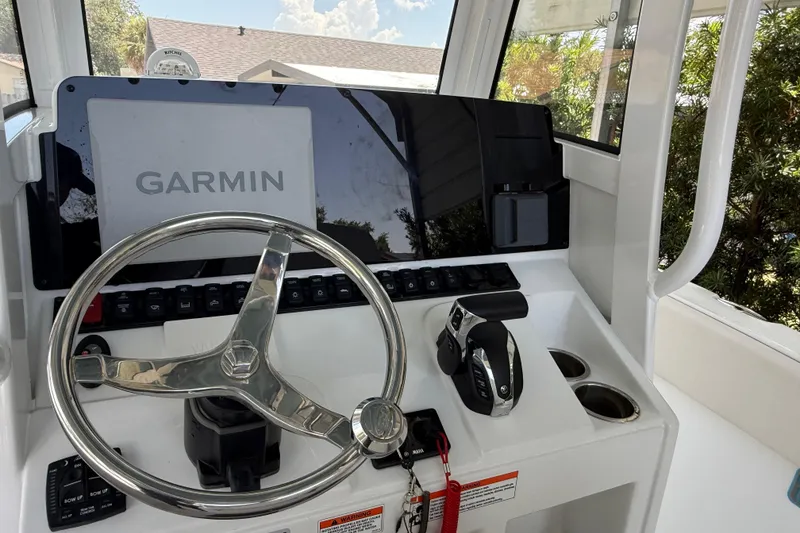 Slide: The Image of 2023 Sea Hunt Ultra 239 SE boat dashboard with Garmin navigation system and steering wheel. - 8