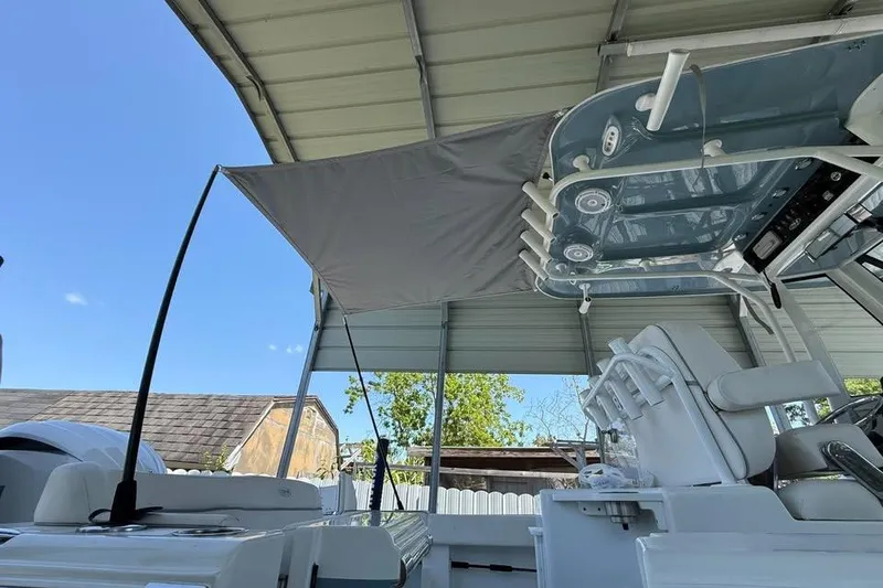Slide: The Image of 2023 Sea Hunt Ultra 239 SE boat under a canopy, showcasing seating and controls. - 4