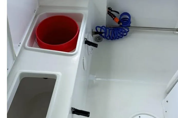 Slide: The Image of 2023 Sea Hunt Ultra 239 SE boat interior with storage compartments and coiled hose. - 5