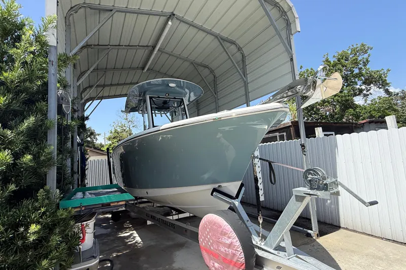 Slide: The Image of 2023 Sea Hunt Ultra 239 SE boat on trailer under a metal canopy. - 24