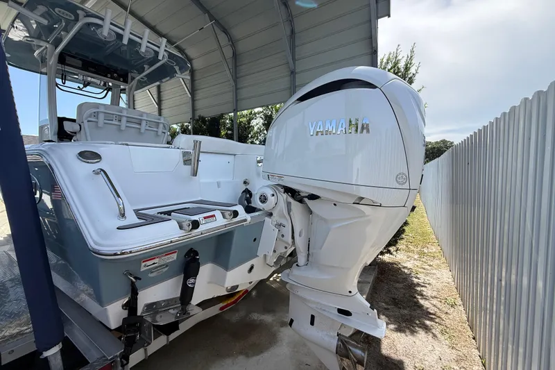 Slide: The Image of 2023 Sea Hunt Ultra 239 SE boat with Yamaha outboard motor, parked under a shelter. - 2
