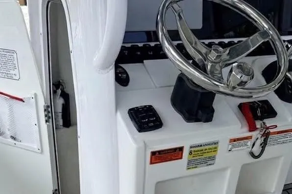 Slide: The Image of 2023 Sea Hunt Ultra 239 SE boat console with steering wheel and controls. - 7