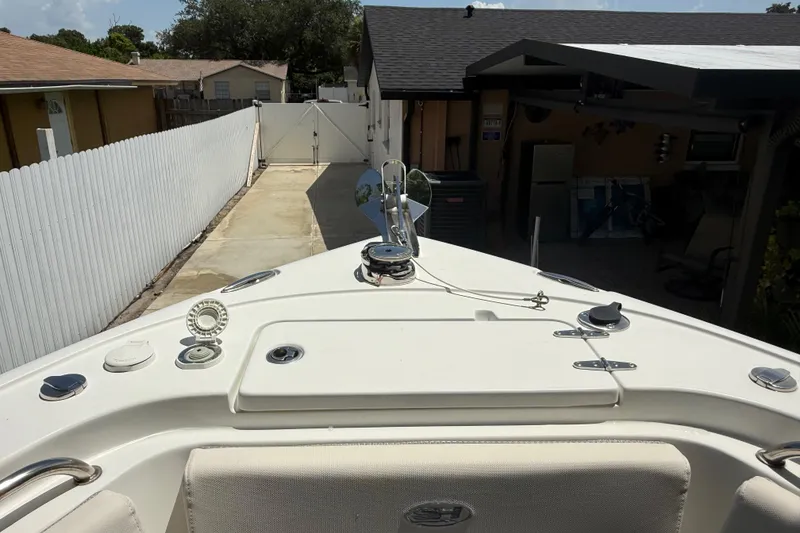 Slide: The Image of 2023 Sea Hunt Ultra 239 SE boat parked in a residential driveway. - 21