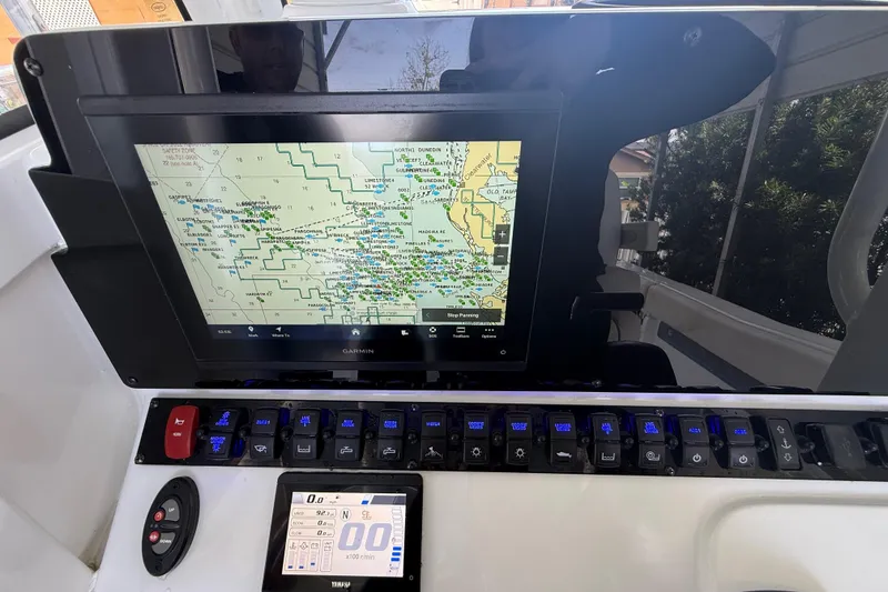 Slide: The Image of Control panel of 2023 Sea Hunt Ultra 239 SE with navigation display and switches. - 10