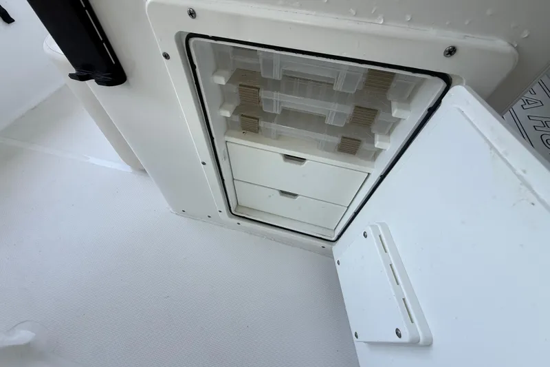Slide: The Image of Storage compartment on 2023 Sea Hunt Ultra 239 SE boat, featuring organized tackle boxes. - 14