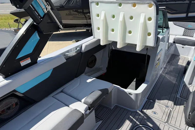 Slide: The Image of 2023 MasterCraft XT24 boat interior with open storage compartment and sleek seating design. - 17