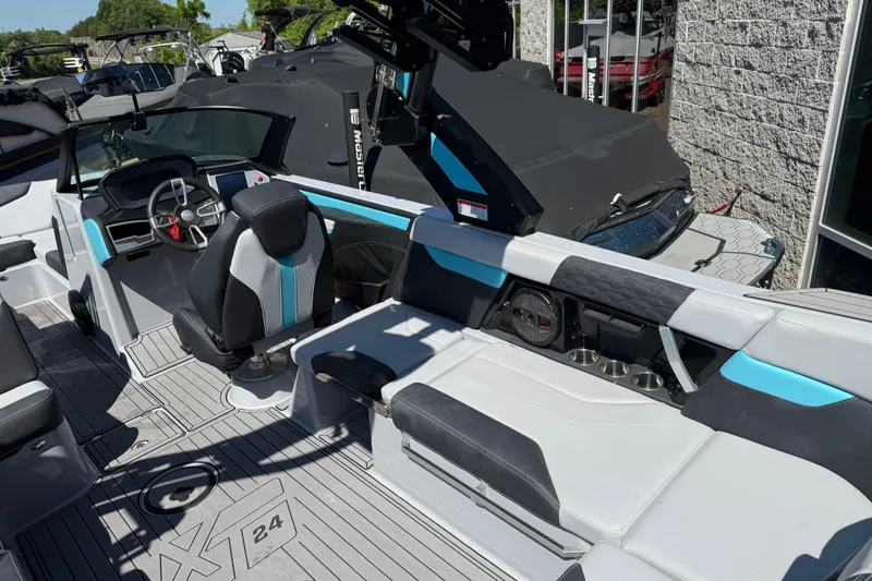 Slide: The Image of 2023 MasterCraft XT24 boat interior with modern seating and steering wheel. - 19