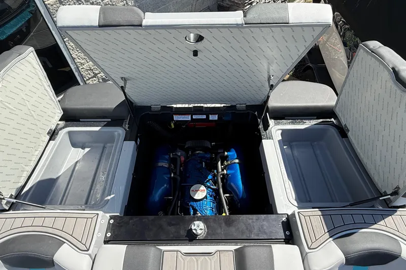 Slide: The Image of 2023 MasterCraft XT24 boat engine compartment with open hatches, showcasing the engine. - 22