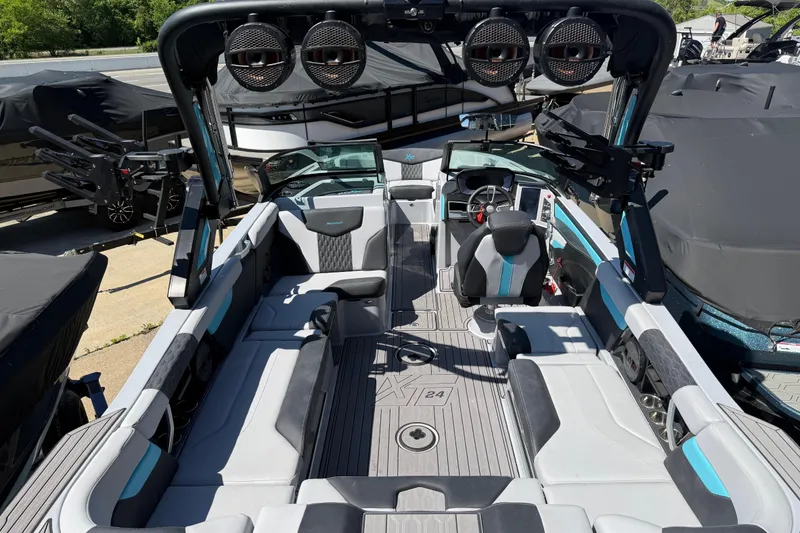 Slide: The Image of 2023 MasterCraft XT24 boat interior with modern seating and advanced audio system. - 24