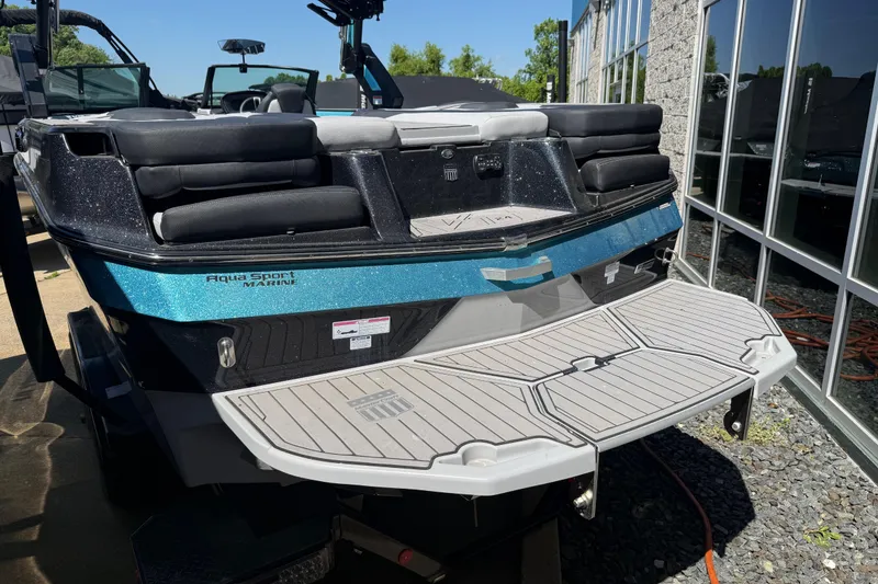 Slide: The Image of 2023 MasterCraft XT24 boat with sleek design and spacious seating at a marina. - 26