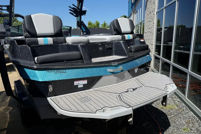 Slide: The Image of 2023 MasterCraft XT24 boat with sleek design and spacious seating, docked outdoors. - 27