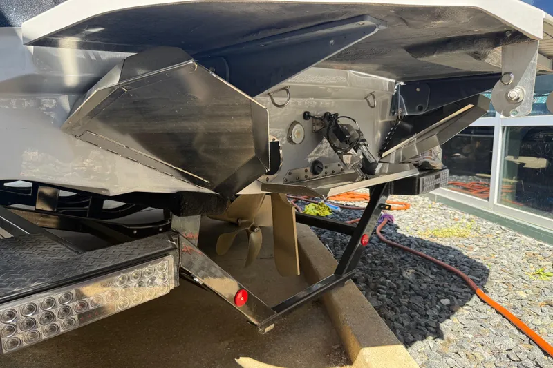 Slide: The Image of 2023 MasterCraft XT24 boat underside showing propeller and trailer details. - 29