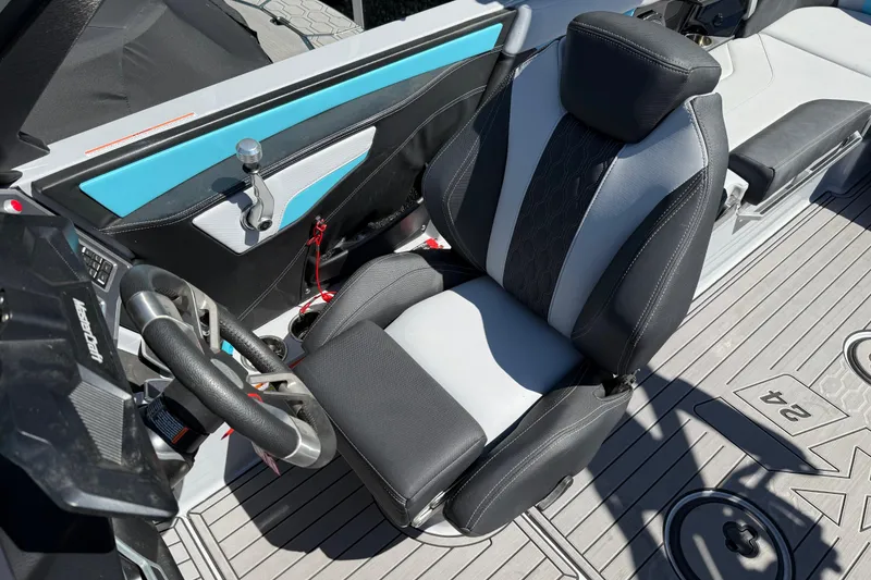 Slide: The Image of 2023 MasterCraft XT24 boat interior with sleek steering wheel and comfortable seating. - 7