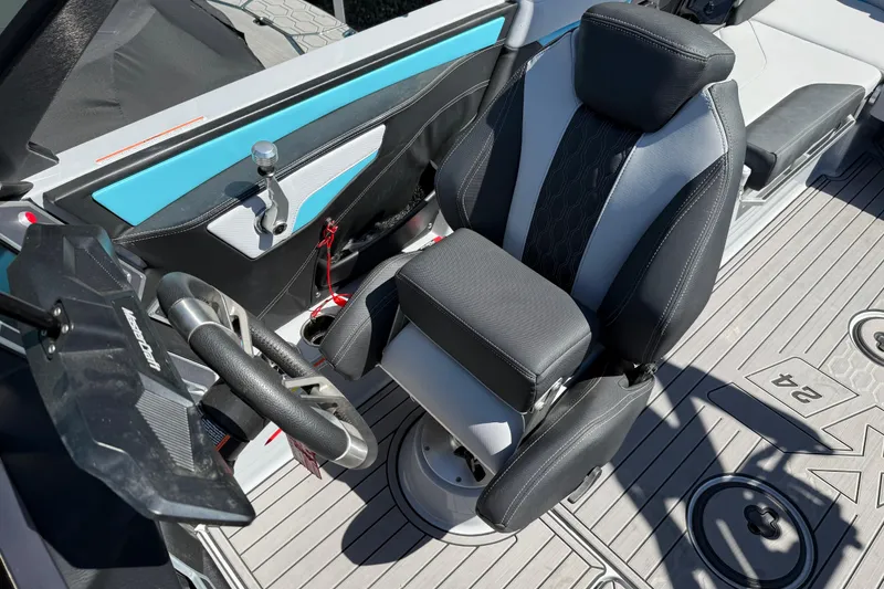 Slide: The Image of 2023 MasterCraft XT24 boat interior with steering wheel and captain's seat. - 8