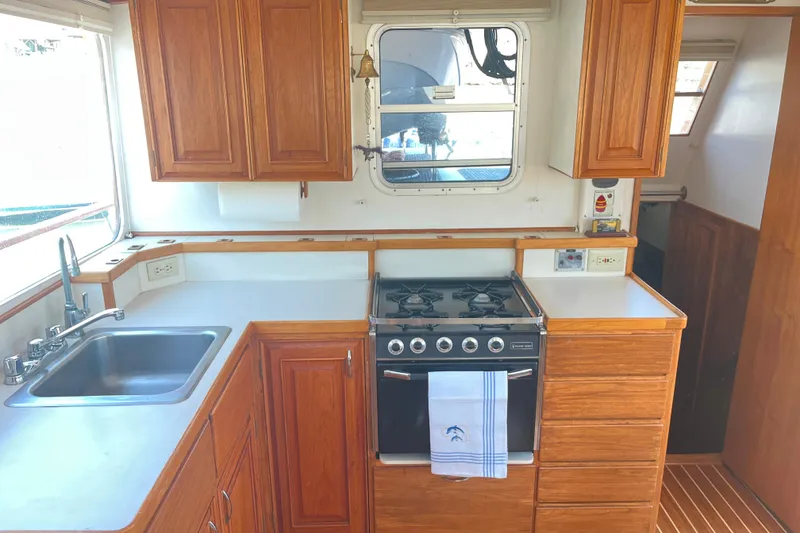 Slide: The Image of 1972 DeFever 38 Passagemaker galley with wooden cabinets, stove, and sink. - 13