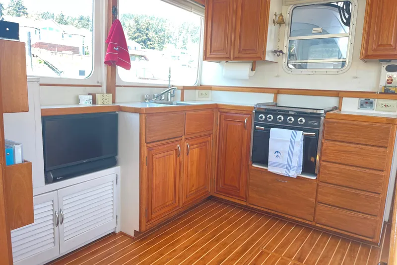 Slide: The Image of 1972 DeFever 38 Passagemaker kitchen with wooden cabinets, stove, and sink. - 14