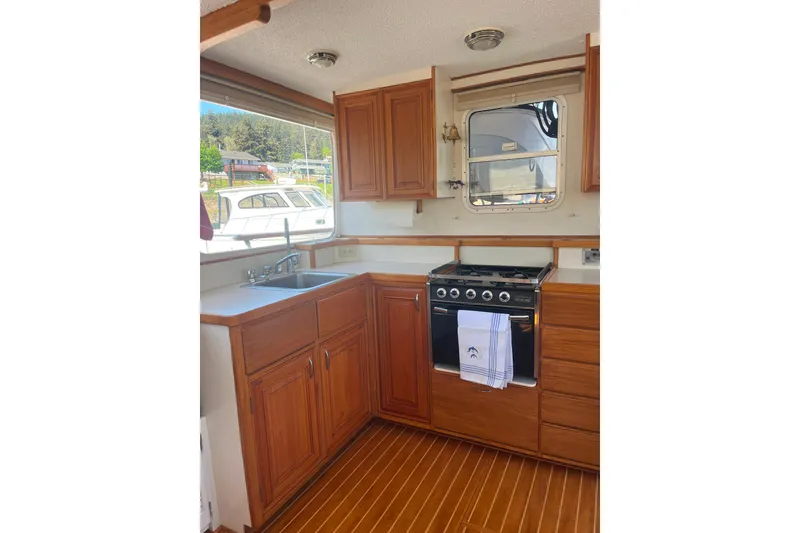 Slide: The Image of 1972 DeFever 38 Passagemaker galley with wooden cabinets, stove, and window view. - 17