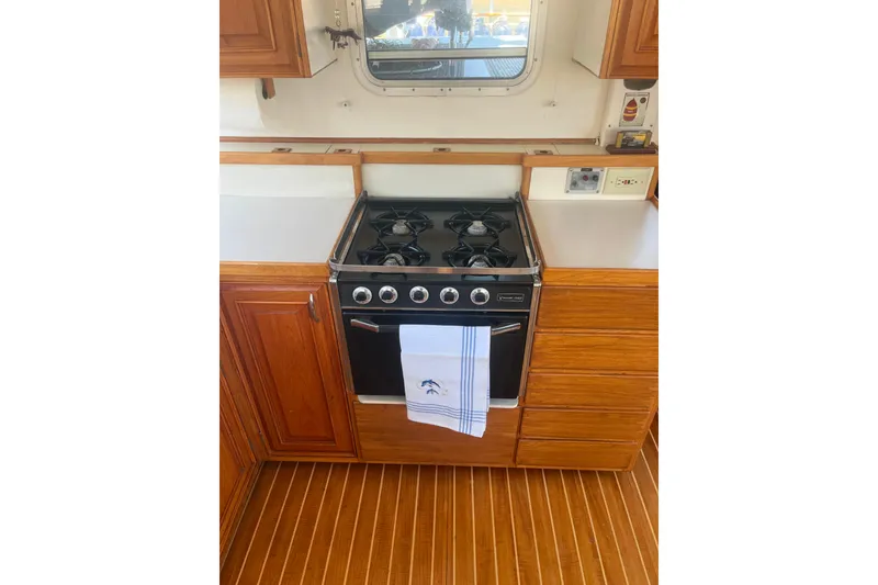 Slide: The Image of 1972 DeFever 38 Passagemaker galley with stove, wooden cabinetry, and striped towel. - 18