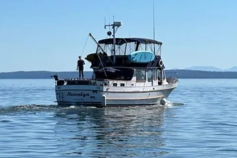 Slide: The Image of 1972 DeFever 38 Passagemaker cruising on calm waters under clear blue skies. - 2