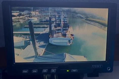 Slide: The Image of CCTV monitor displaying a marina with docked boats, including a 1972 DeFever 38 Passagemaker. - 31