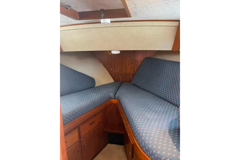 Slide: The Image of 1972 DeFever 38 Passagemaker cabin with blue patterned cushions and wooden storage cabinets. - 36