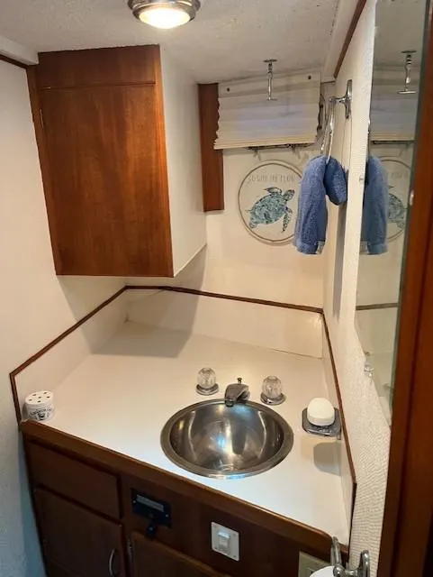 Slide: The Image of 1972 DeFever 38 Passagemaker bathroom with sink, wooden cabinets, and nautical decor. - 46