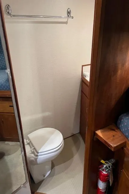 Slide: The Image of 1972 DeFever 38 Passagemaker bathroom with toilet, wooden cabinetry, and fire extinguisher. - 48