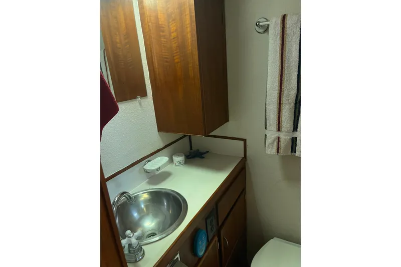 Slide: The Image of 1972 DeFever 38 Passagemaker bathroom with wooden cabinets, stainless steel sink, and towel rack. - 67