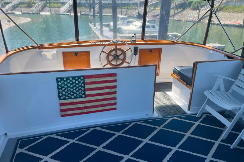 Slide: The Image of 1972 DeFever 38 Passagemaker helm with American flag decor and nautical seating. - 69