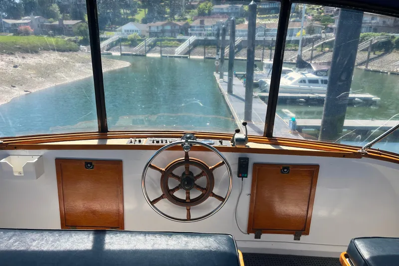 Slide: The Image of Interior view of 1972 DeFever 38 Passagemaker helm with marina backdrop. - 70