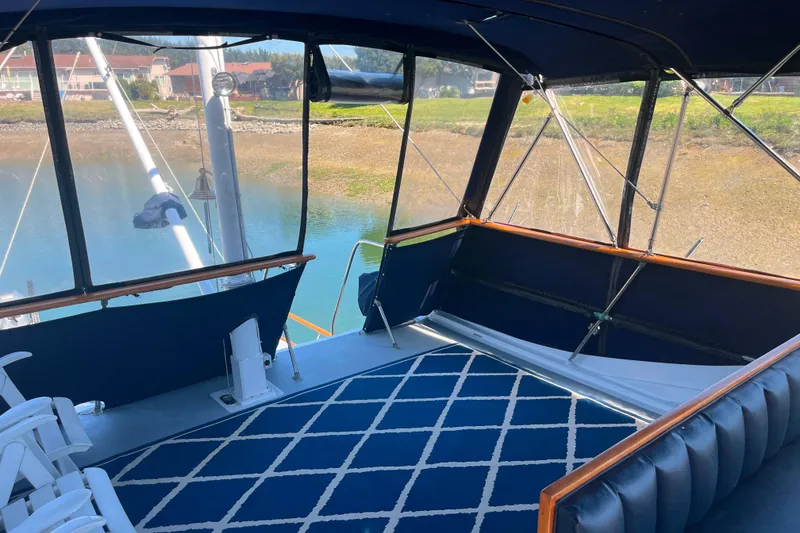 Slide: The Image of 1972 DeFever 38 Passagemaker yacht interior with blue carpet and cushioned seating. - 74