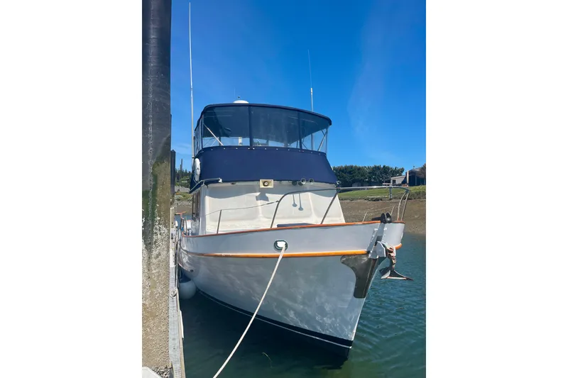Slide: The Image of 1972 DeFever 38 Passagemaker yacht docked, featuring classic design and blue canopy. - 92