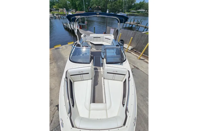 Slide: The Image of 2018 Sea Ray SLX 230 boat with spacious seating, docked by a serene waterfront. - 13