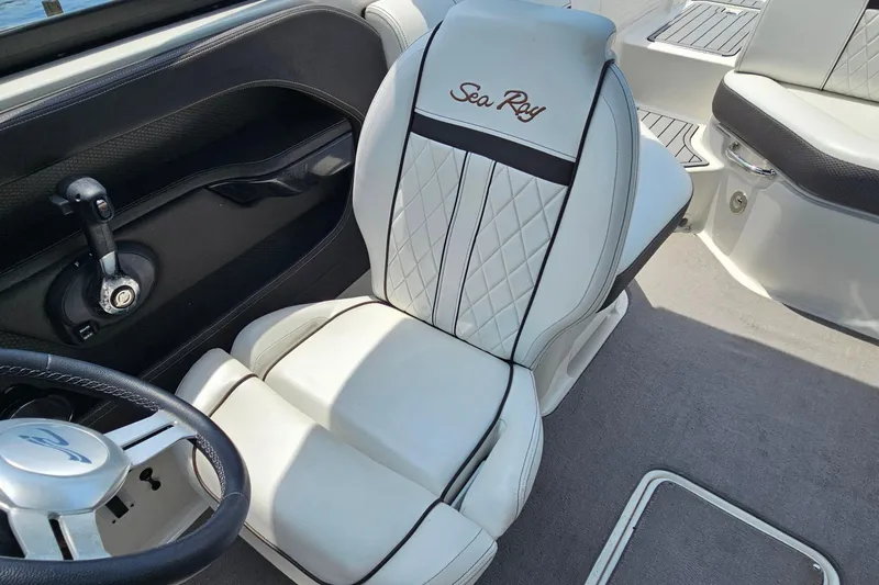 Slide: The Image of 2018 Sea Ray SLX 230 interior with luxurious white seating and steering wheel. - 17