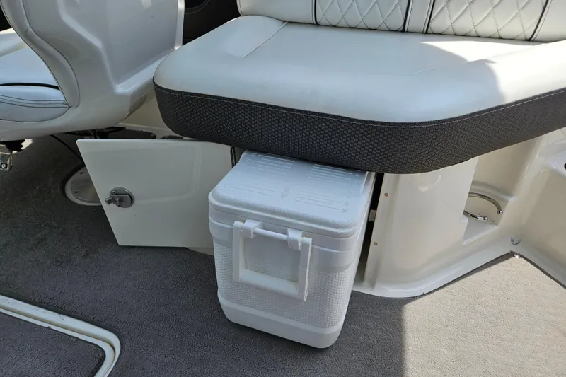 Slide: The Image of 2018 Sea Ray SLX 230 boat interior with cooler storage under cushioned seat. - 22