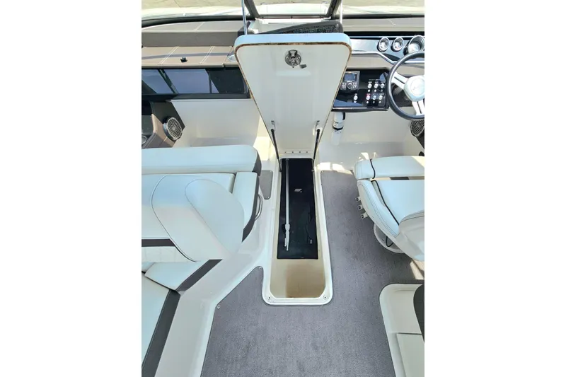 Slide: The Image of 2018 Sea Ray SLX 230 boat interior with open storage compartment and seating. - 26