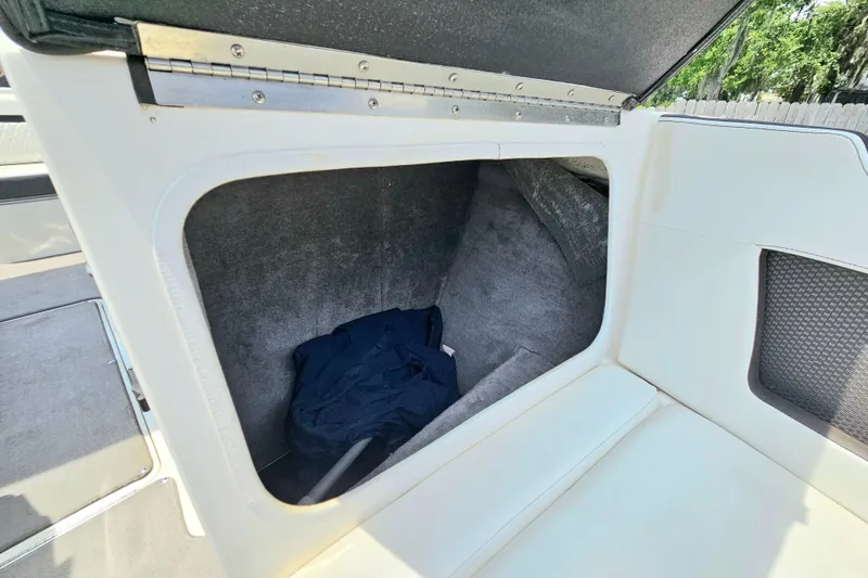 Slide: The Image of 2018 Sea Ray SLX 230 boat storage compartment with open hatch and interior view. - 28