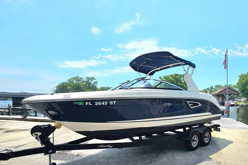 Slide: The Image of 2018 Sea Ray SLX 230 boat on trailer by waterfront, clear sky background. - 6