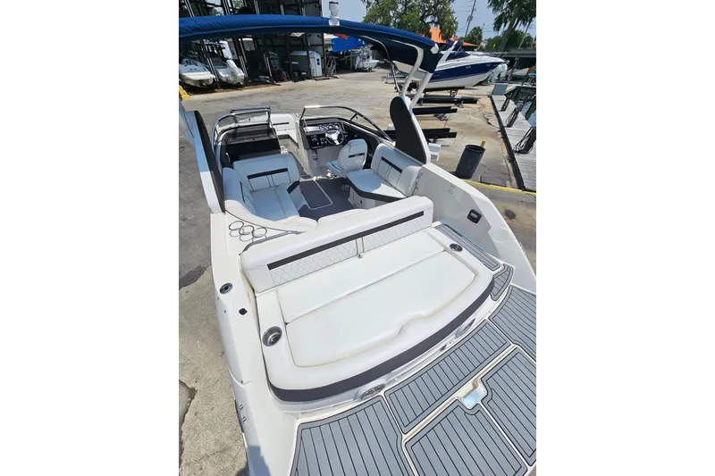 Slide: The Image of 2018 Sea Ray SLX 230 boat with spacious seating and sleek design at a marina. - 7