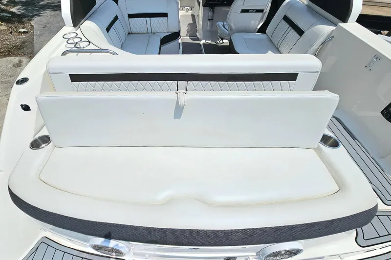 Slide: The Image of 2018 Sea Ray SLX 230 boat interior with white seating and cup holders. - 8